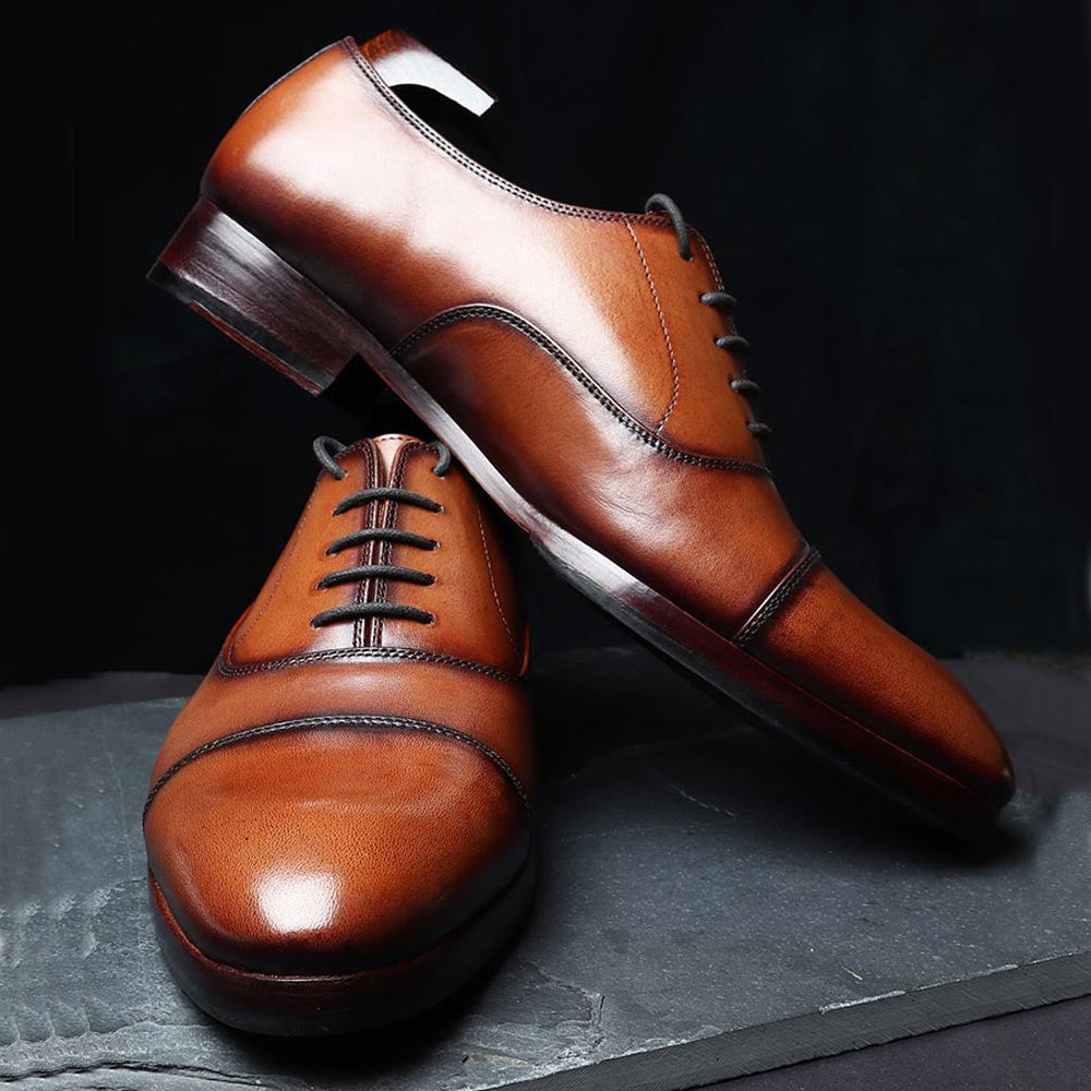 Brown leather cap-toe Oxford formal shoes for men with lace-up closure.