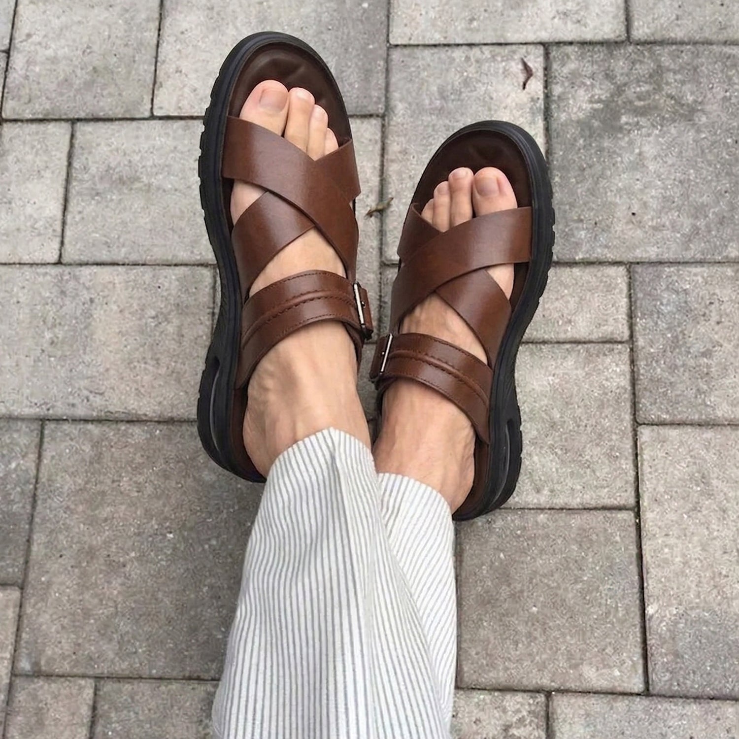 Brown men’s cross strap sandals with adjustable buckle and cushioned sole