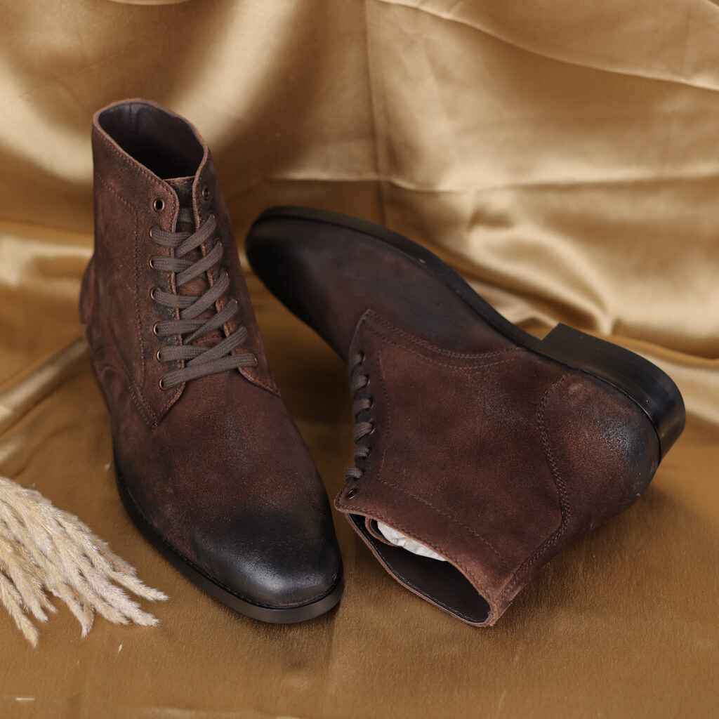 A pair of Combat Brown boots made from durable oil pull-up leather in a rich brown shade. Featuring a Dainite sole for excellent traction and durability, these sturdy boots combine timeless style with practical functionality, ideal for casual outings and outdoor adventures.

