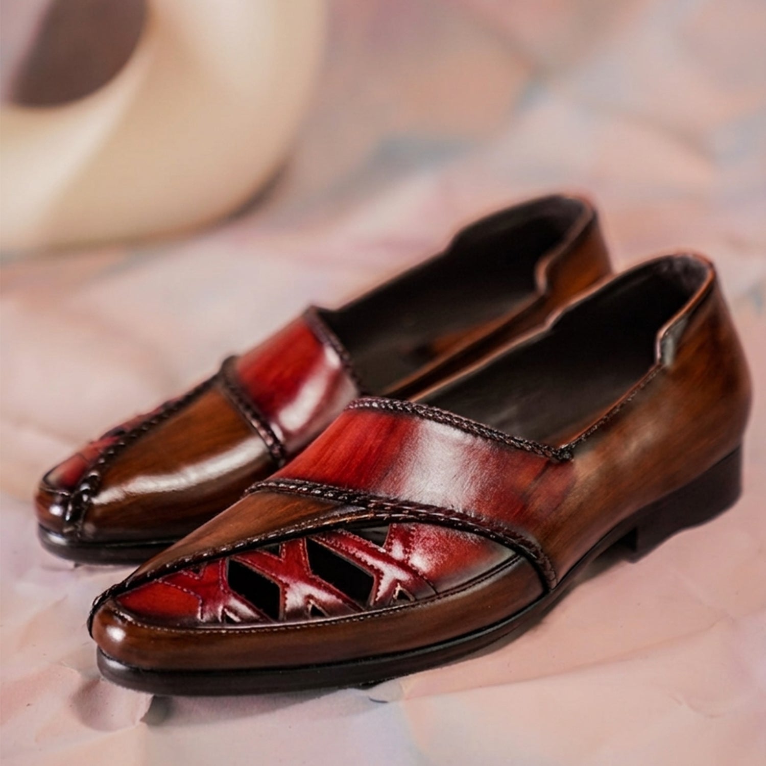 Pair of luxury hand-painted burgundy and brown leather loafers with detailed stitching and sleek slip-on design for men