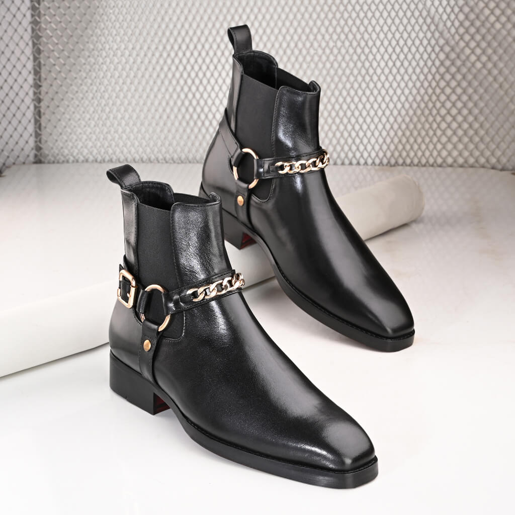 "Regent Black Chain Chelsea Boots by Mille Dollari—handcrafted black leather boots with an elegant gold chain, offering sophistication, comfort, and a bold statement look."





