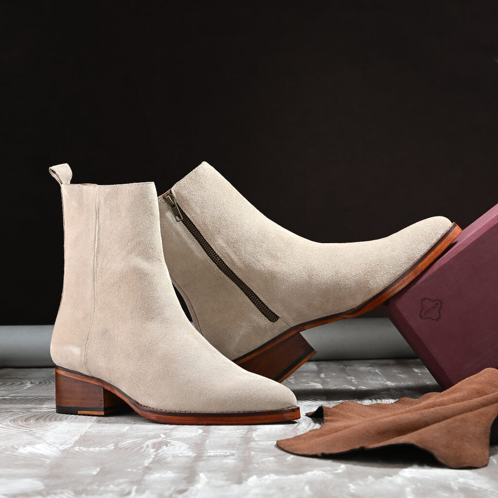 "Off-white creamy suede ankle boots with a sleek silhouette, soft suede upper, and sturdy wooden sole—perfect for effortless minimalist elegance and versatile styling."






