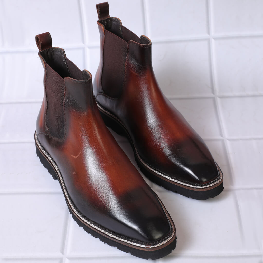 "Brown and black gradient Chelsea boots crafted from premium leather, featuring a seamless color transition, elastic side panels, pull tabs, and sturdy soles for style and durability."

