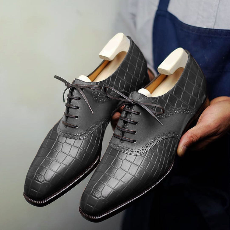Premium black crocodile embossed leather Oxford brogue dress shoes for men featuring closed-lace construction, brogue detailing, elegant craftsmanship, and wooden shoe trees.