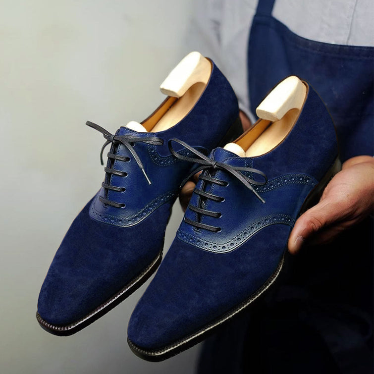 Premium navy blue suede Oxford brogue dress shoes for men featuring genuine leather brogue detailing, closed-lace construction, elegant craftsmanship, and wooden shoe trees.