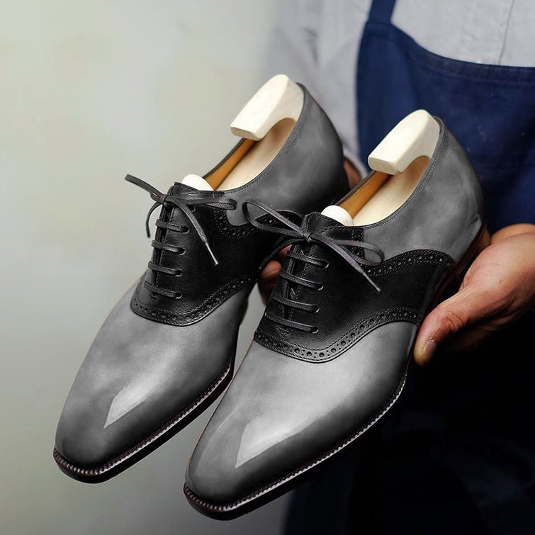 Premium men's grey leather Derby shoes with black brogue detailing, polished finish, classic lace-up closure, refined cap-toe design, and sophisticated formal styling for office wear, weddings, business meetings, and special occasions.